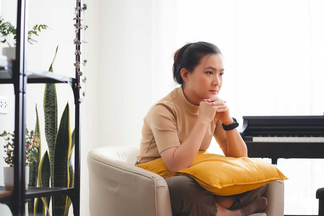 A woman thinking while sitting on couch
