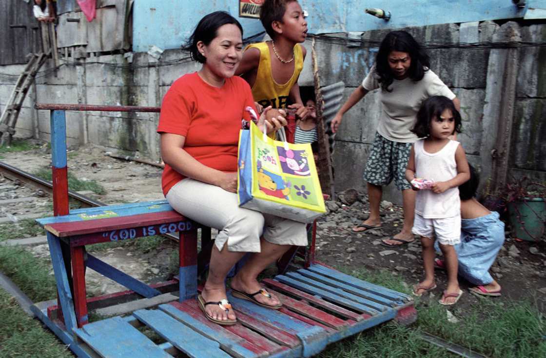 Woman sits outdoor with her children