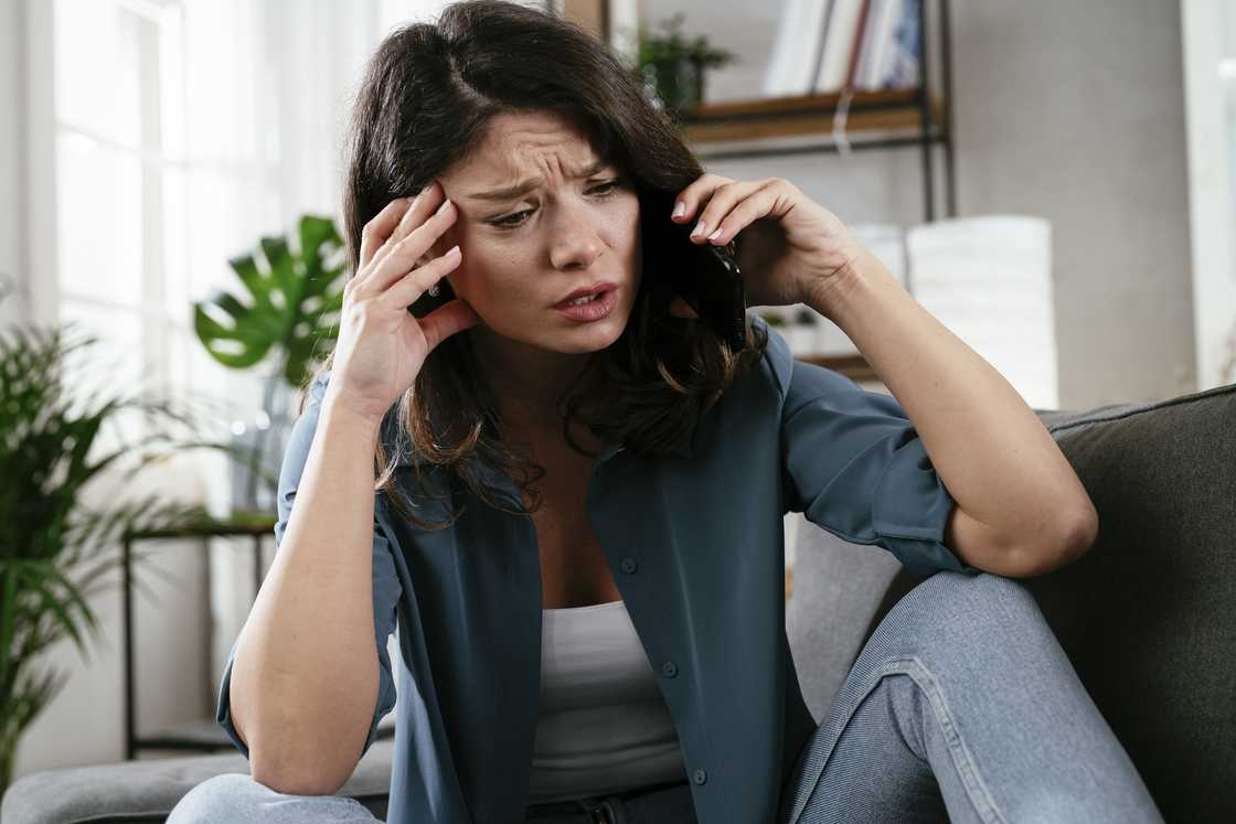 A woman worried while talking on her cellphone