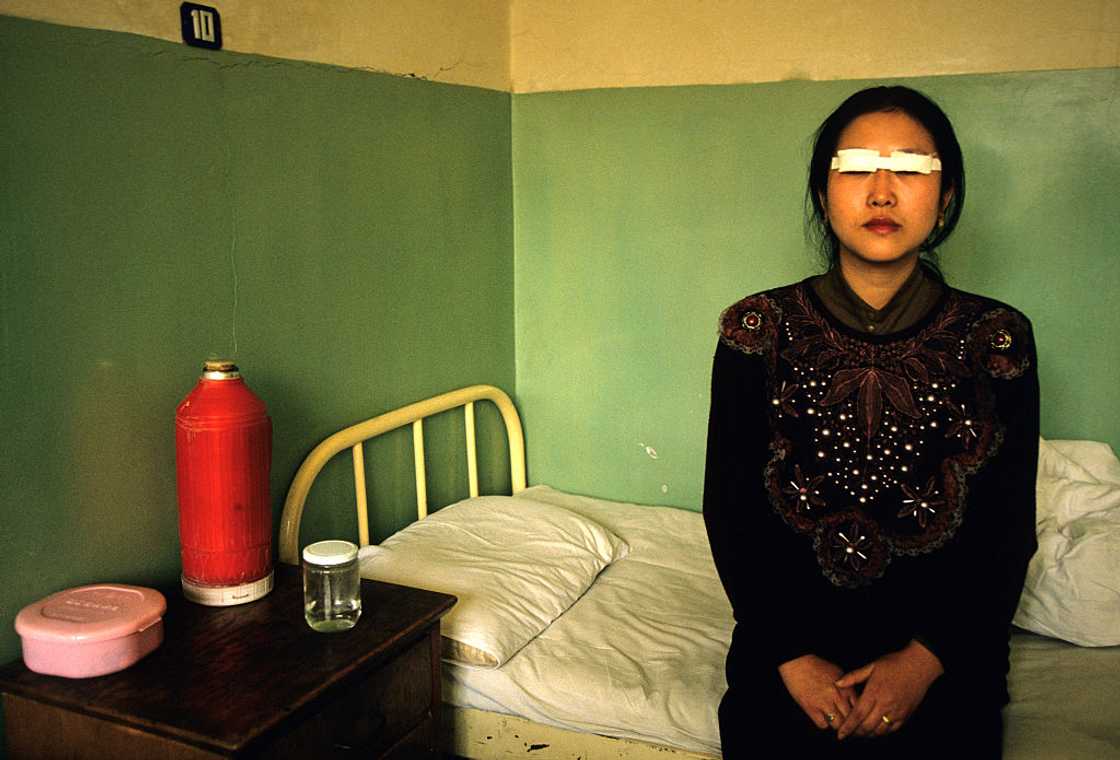 Asian woman recovering in hospital.