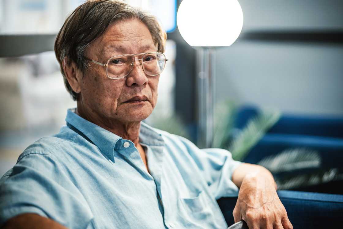 A sad senior man sitting in waiting room