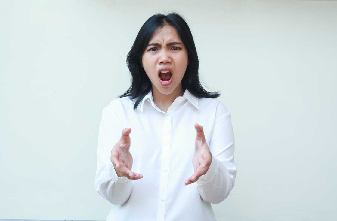 A furious woman shouting while looking at the camera A furious woman shouting while looking at the camera