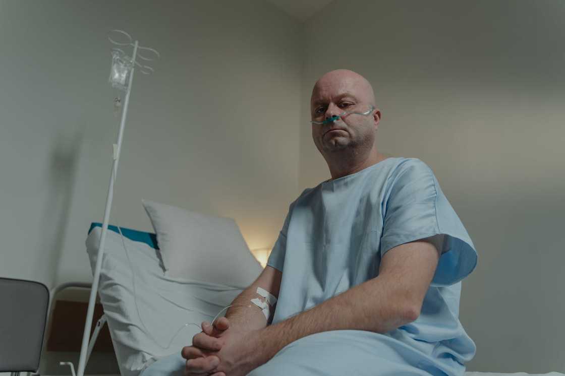 A man in sits on a hospital bed. A man in sits on a hospital bed.
