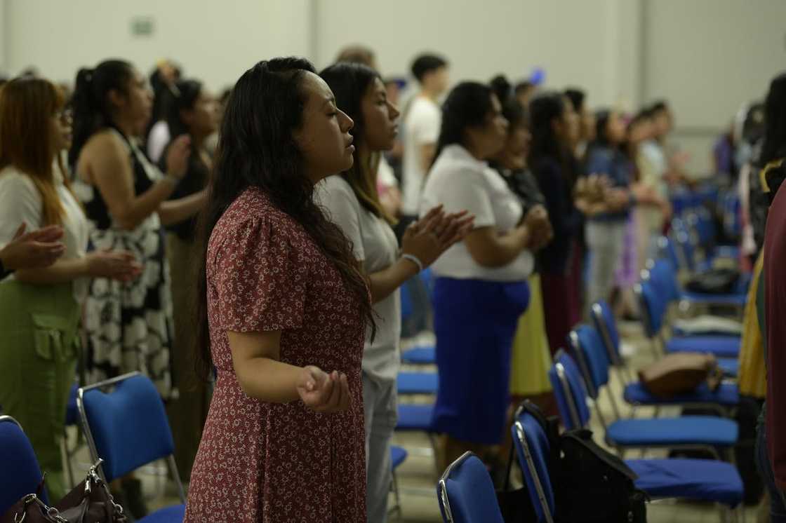People standing during prayer inside a church gathering. People standing during prayer inside a church gathering.