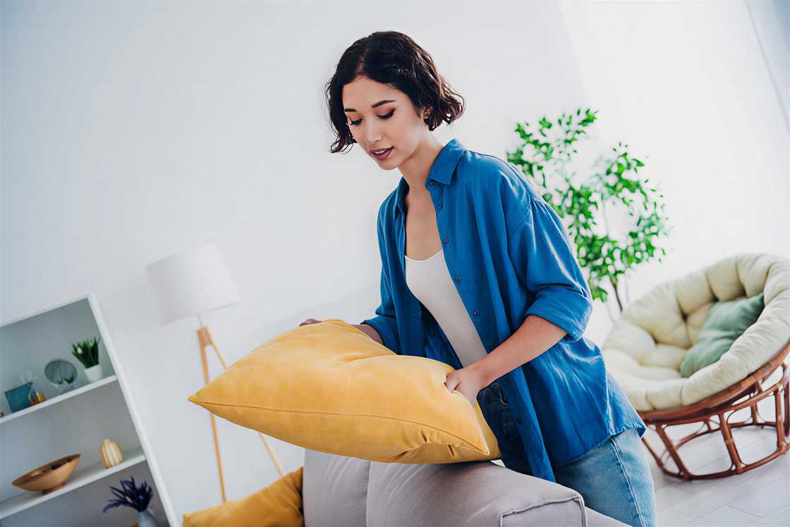 A young woman is arranging cushion