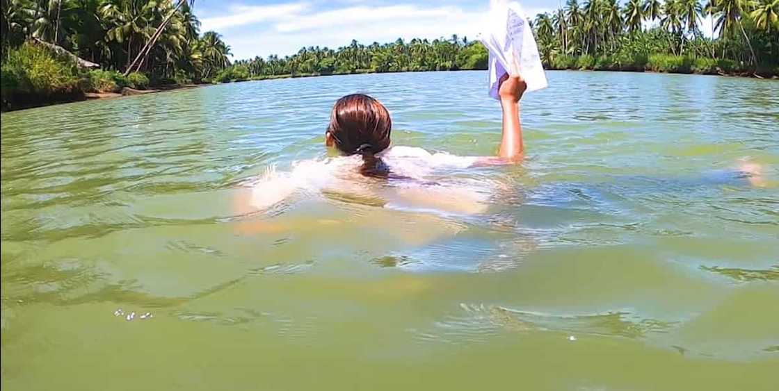 Guro, nilangoy ang hanggang leeg na ilog para mahatid ang module sa mga estudyante Guro, nilangoy ang hanggang leeg na ilog para mahatid ang module sa mga estudyante