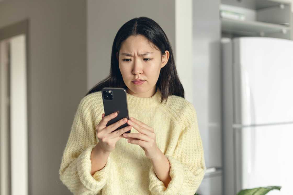 An angry young woman looking at her phone