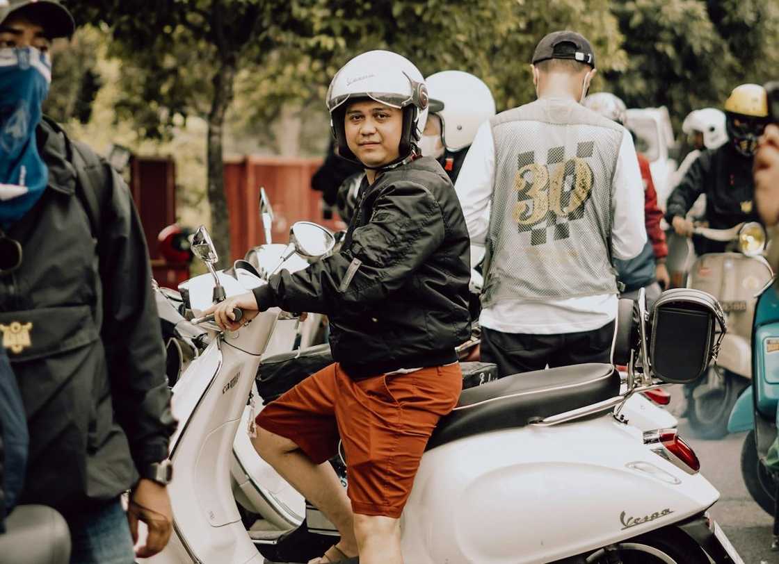 A group of riders sitting on scooter motorbikes.