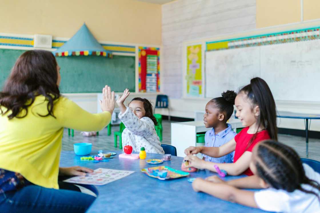 A woman counselling a group of children A woman counselling a group of children