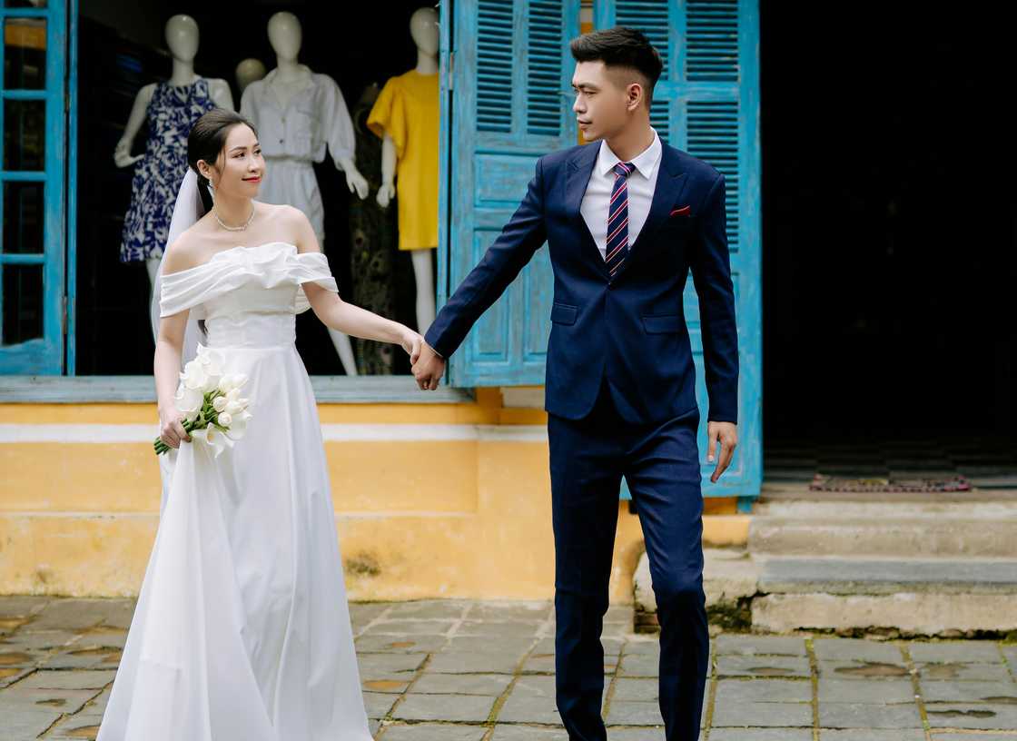 A newly wedded couple holding hands