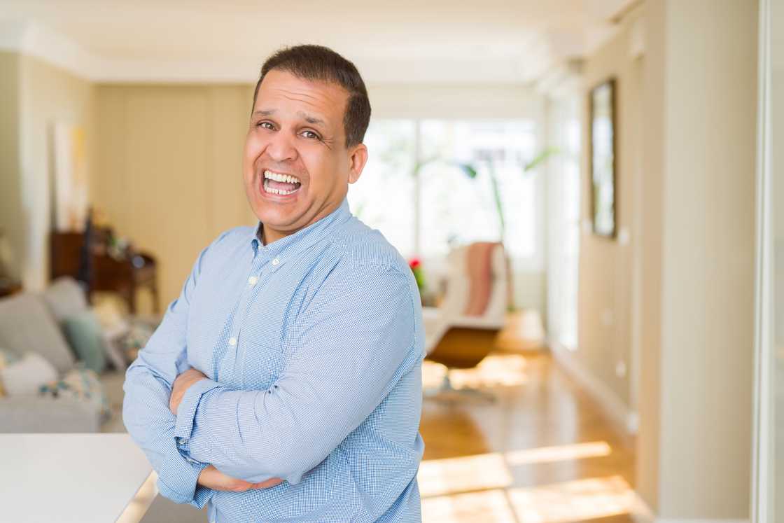 a senior man faking a laughter at home a senior man faking a laughter at home