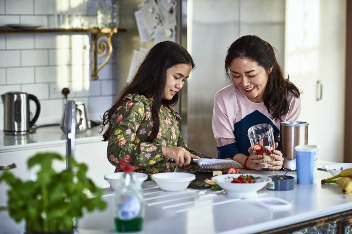 A mother and daughter are cooking on the kitchen A mother and daughter are cooking on the kitchen