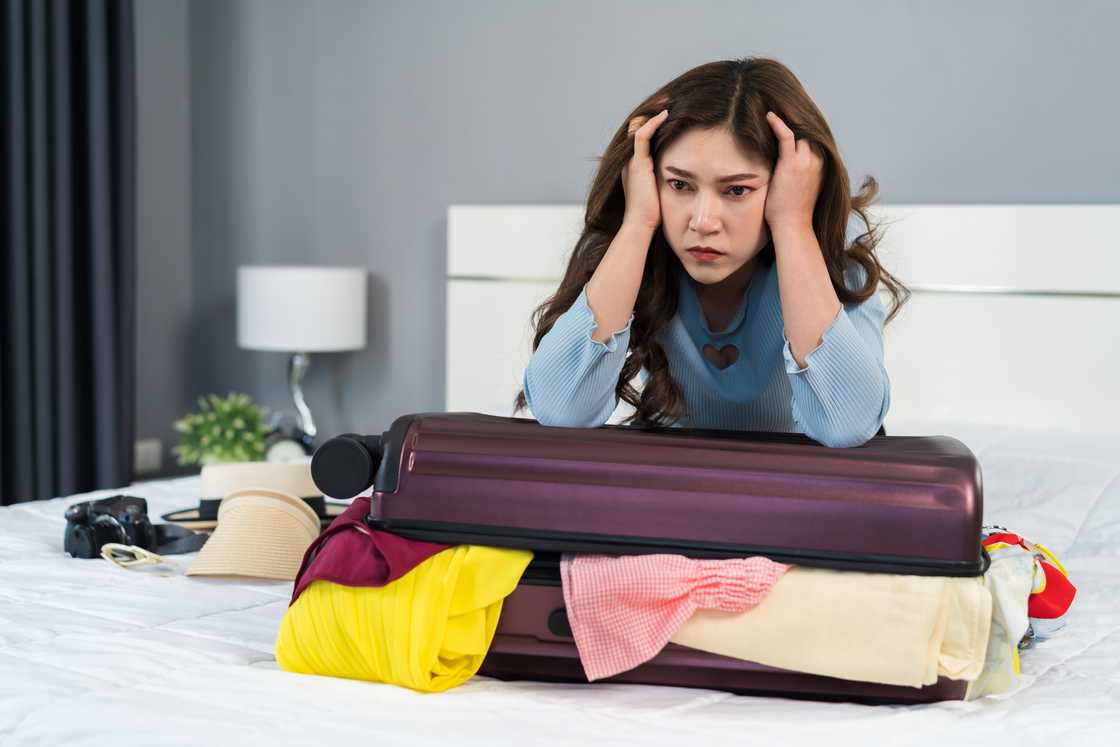 a sad woman packing her suitcase at home a sad woman packing her suitcase at home