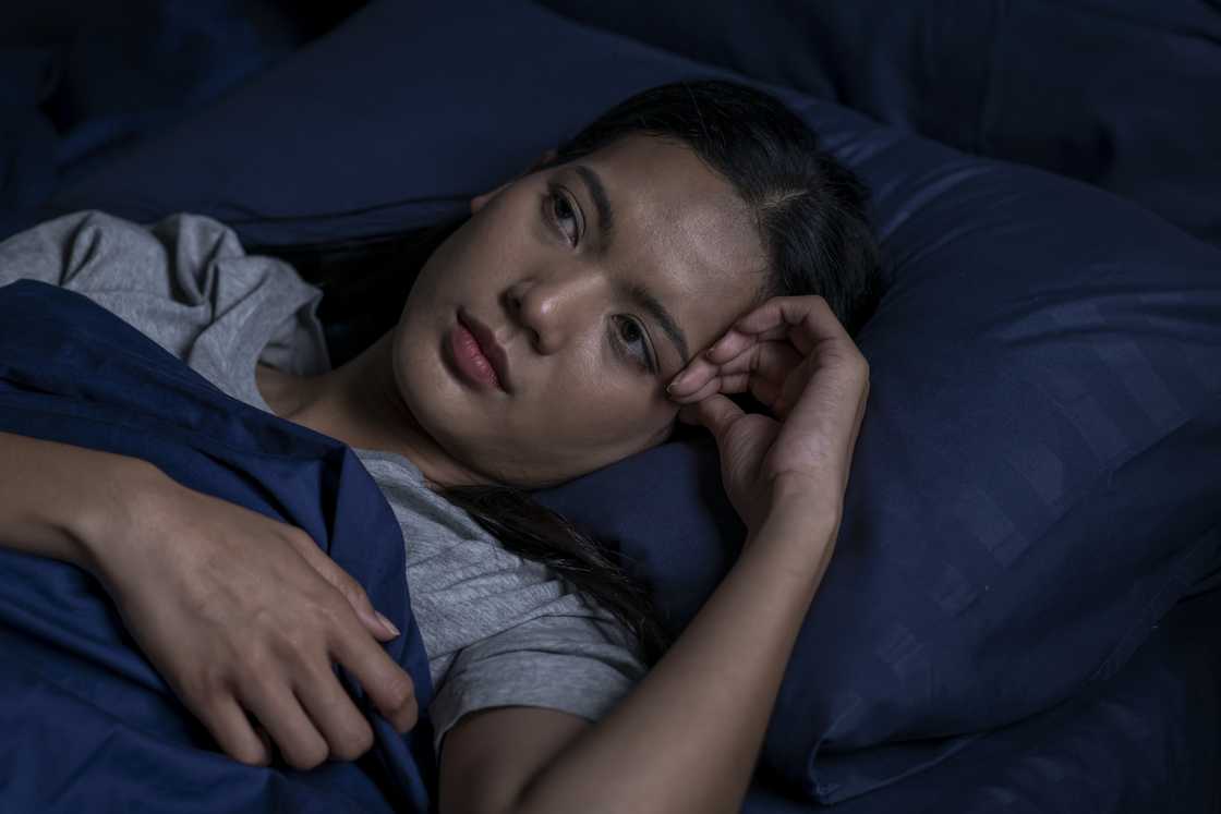 A stressed young woman having difficulty sleeping