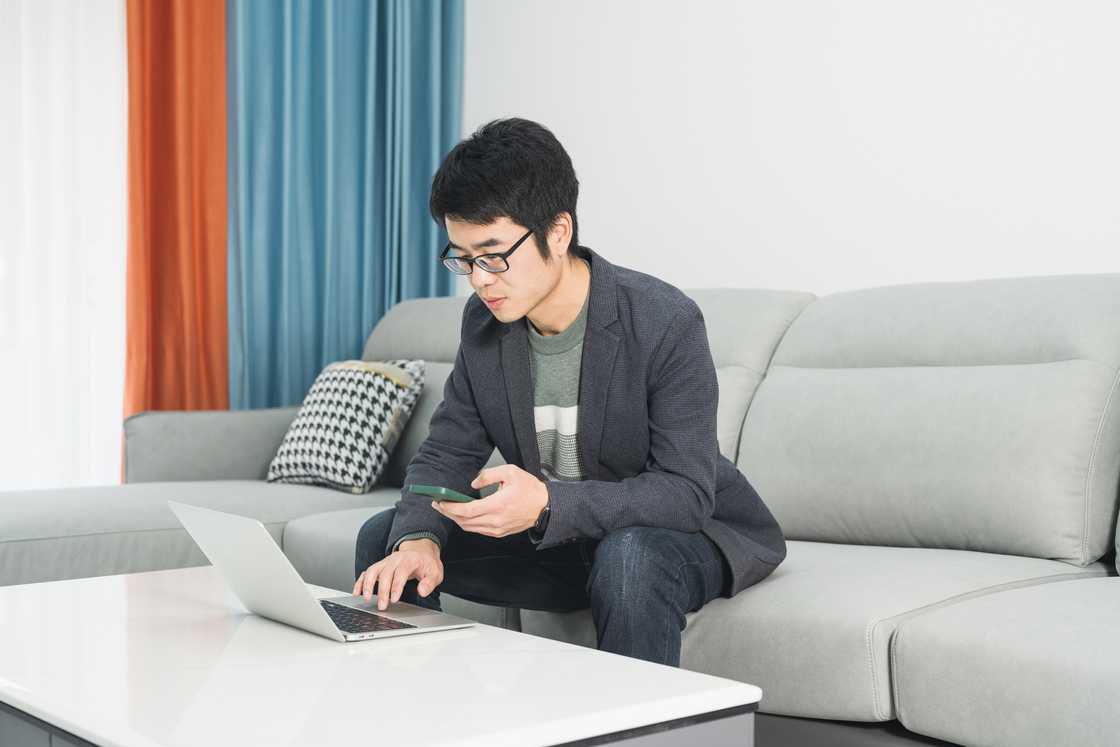 A young man working in the living room A young man working in the living room