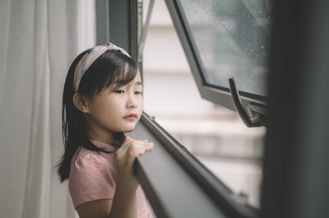 An Asian young child looking out An Asian young child looking out