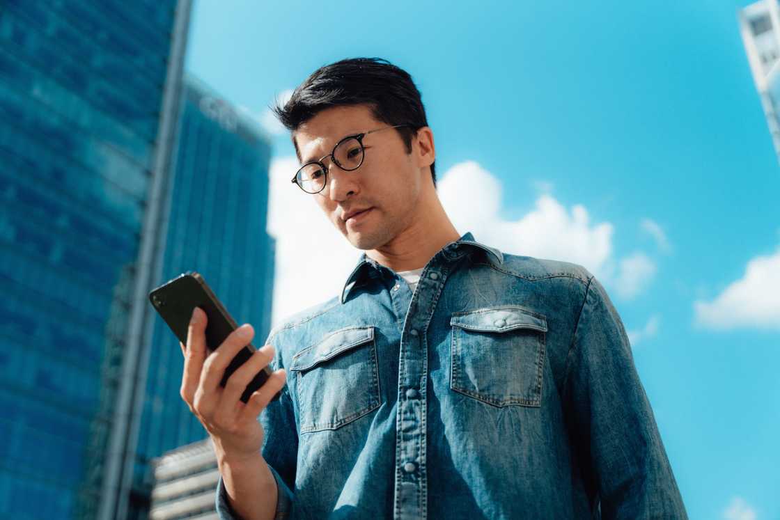 Young Asian businessman using a smartphone Young Asian businessman using a smartphone