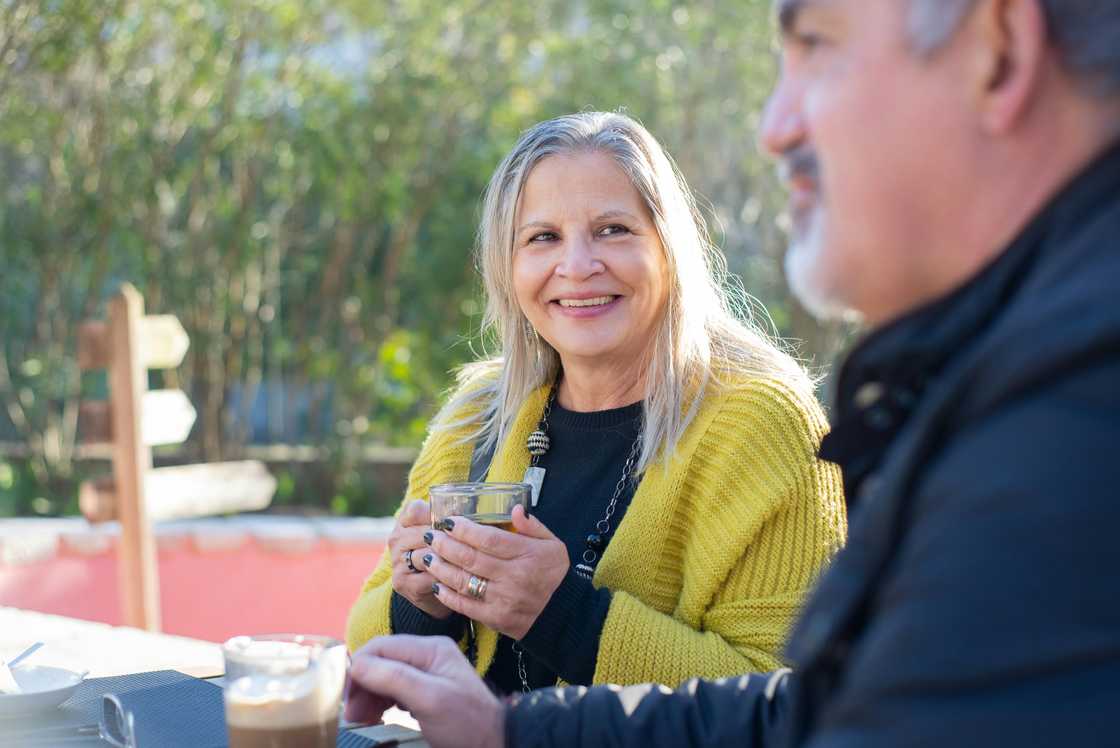 A man and woman sitting outdoors having coffee A man and woman sitting outdoors having coffee