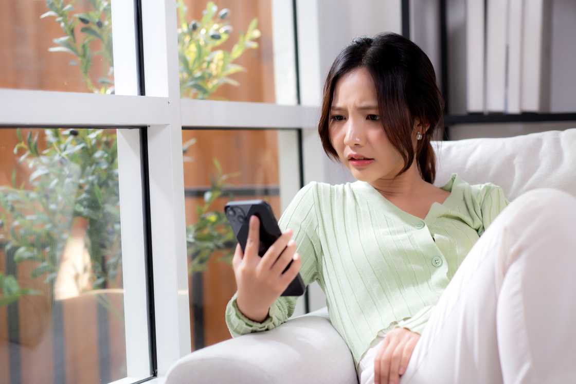 A worried woman looking at her smart phone A worried woman looking at her smart phone