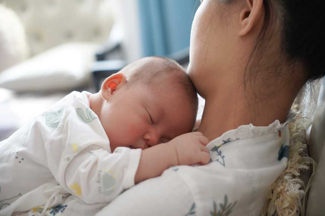 A close-up of a mother holding a baby. A close-up of a mother holding a baby.