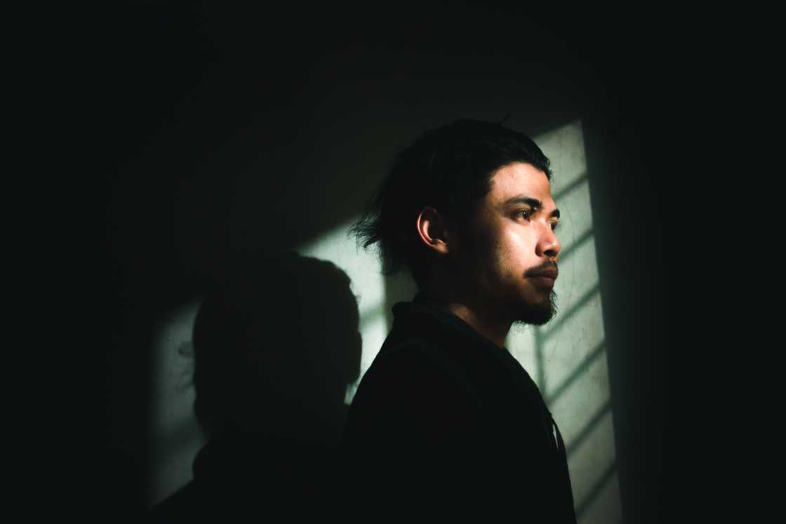 A stressed man in a dark room A stressed man in a dark room