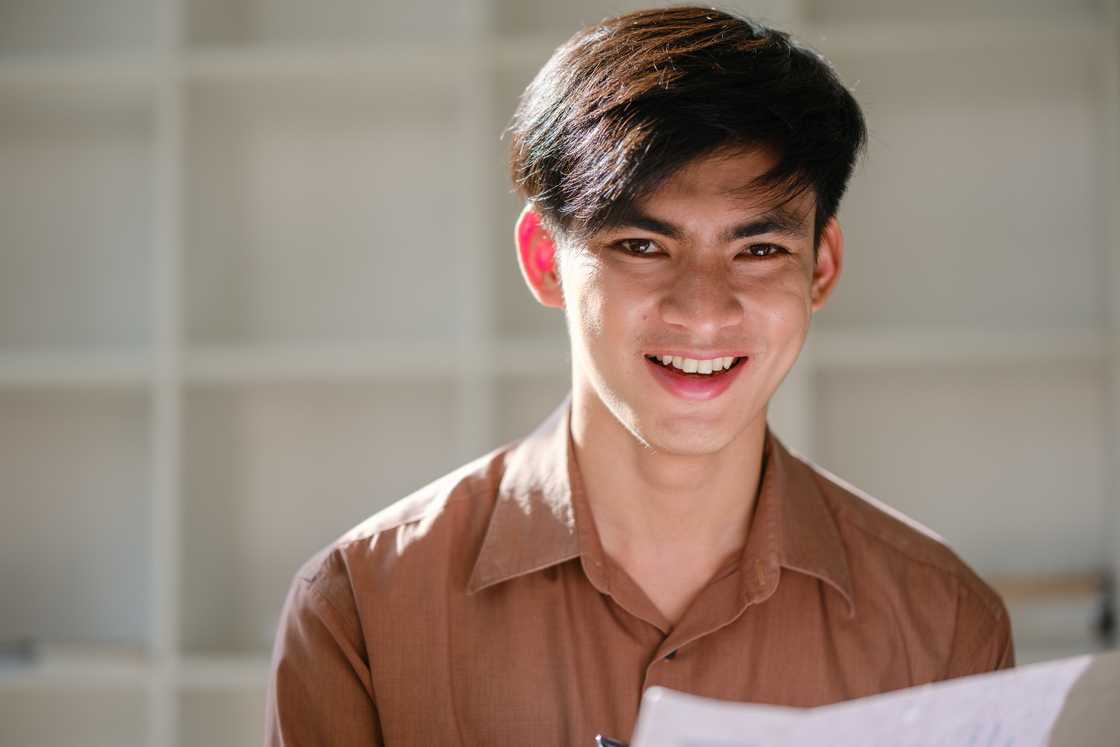 a young man holding internship letter a young man holding internship letter