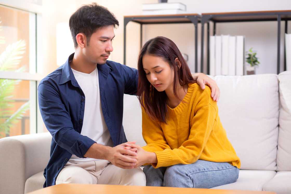 A caring man comforts sad woman