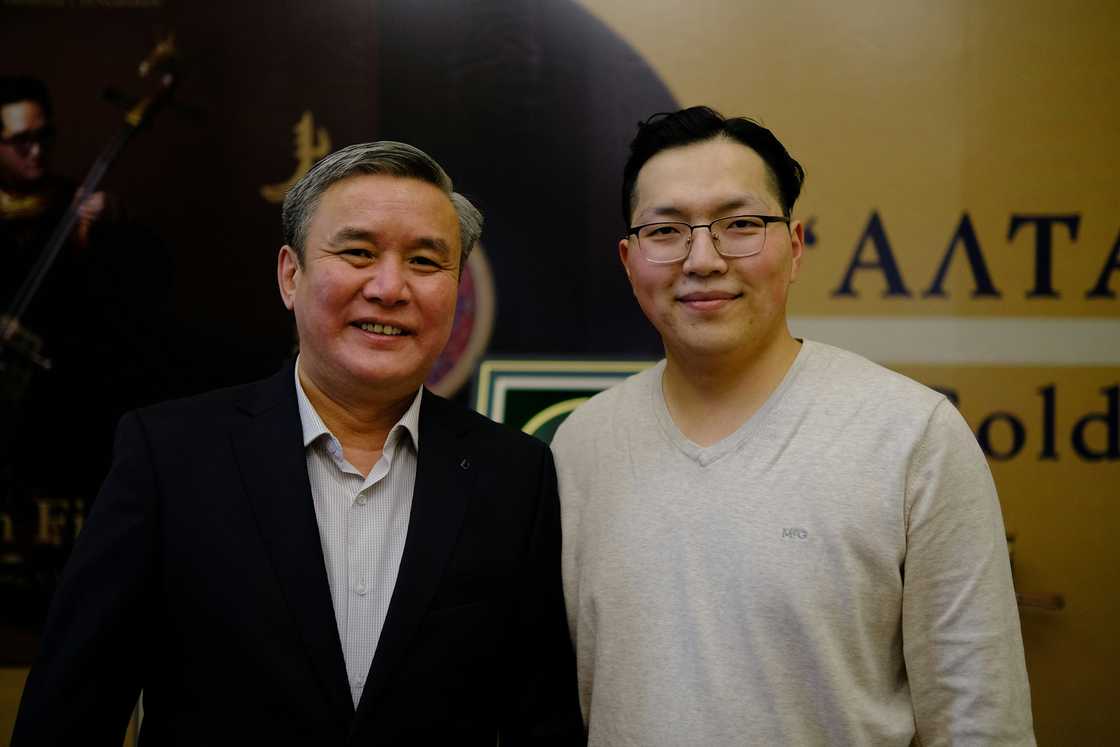 Two people pose side by side at an event. Two people pose side by side at an event.