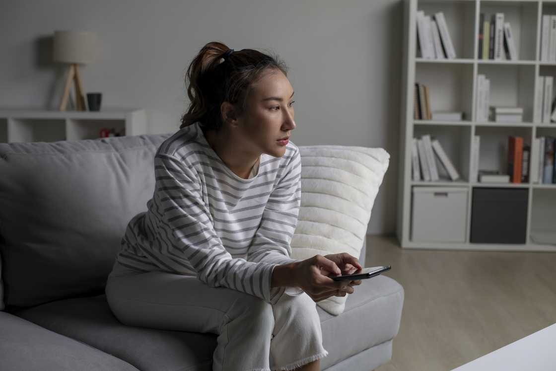 A stressed woman holds her phone A stressed woman holds her phone