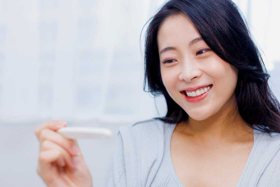 A woman happy with the result of pregnancy test kit A woman happy with the result of pregnancy test kit