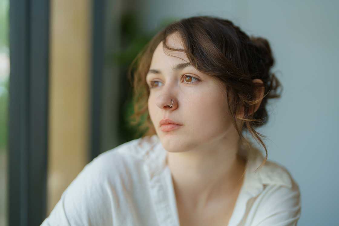 A woman sitting and looking through the window A woman sitting and looking through the window