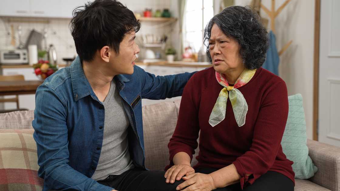 A worried asian mother is complaining to her adult son A worried asian mother is complaining to her adult son