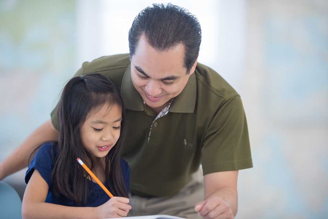 A father and his young daughter are doing homework A father and his young daughter are doing homework
