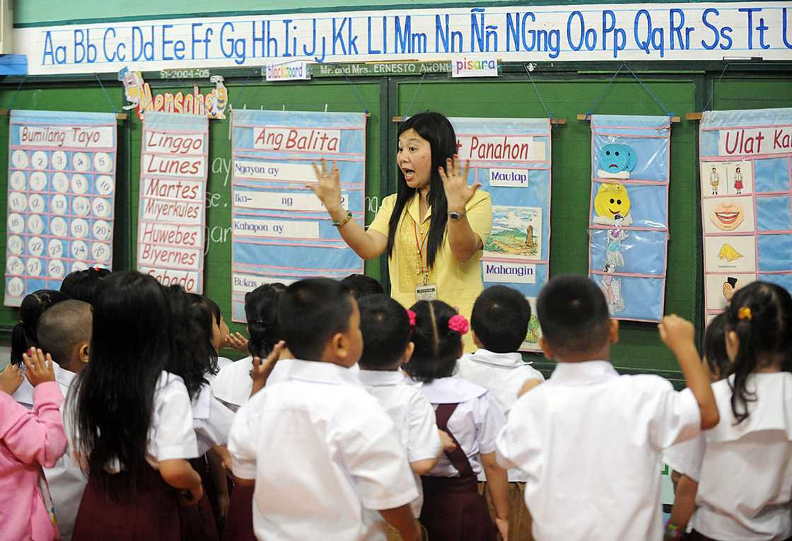 Asian teacher in class demonstrating to students. Asian teacher in class demonstrating to students.