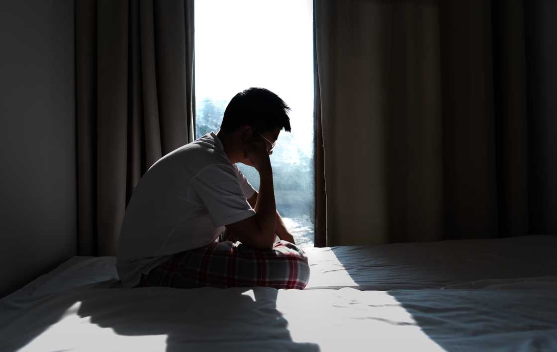 A sad teen boy in his room