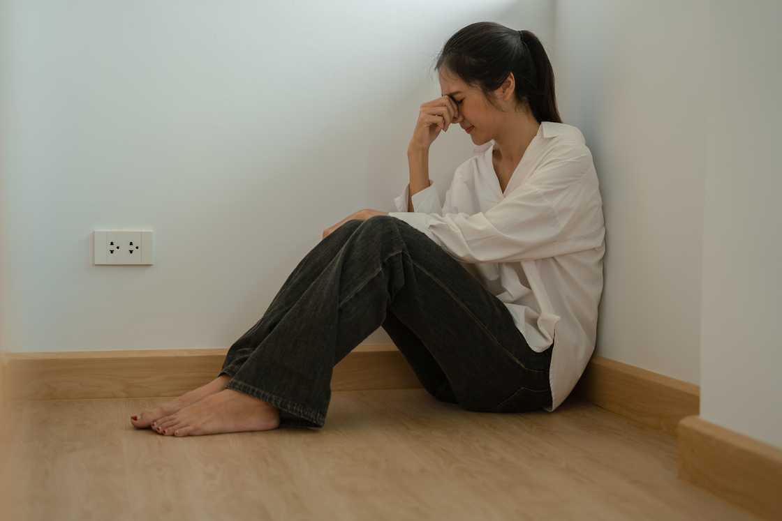 A depressed woman woman sitting on floor A depressed woman woman sitting on floor