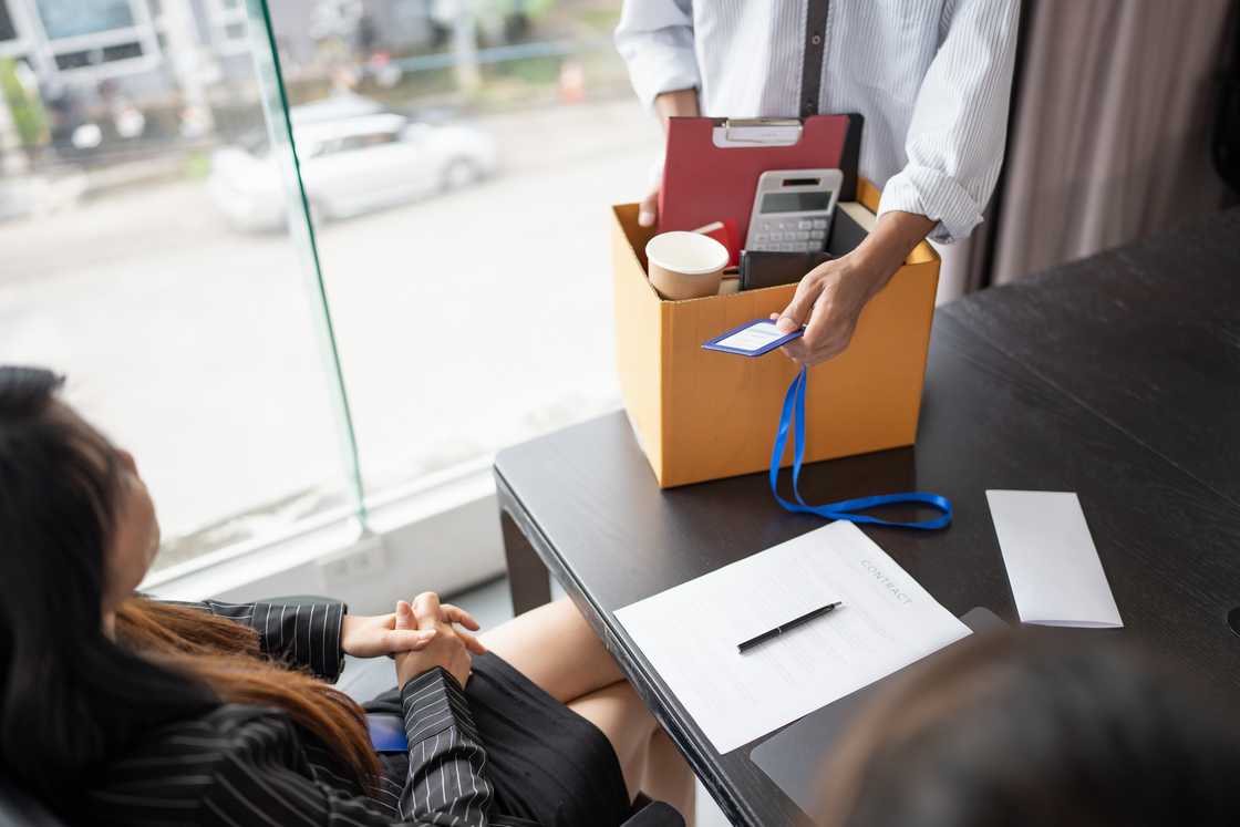 An employee holding his belongings in a box after losing a job An employee holding his belongings in a box after losing a job