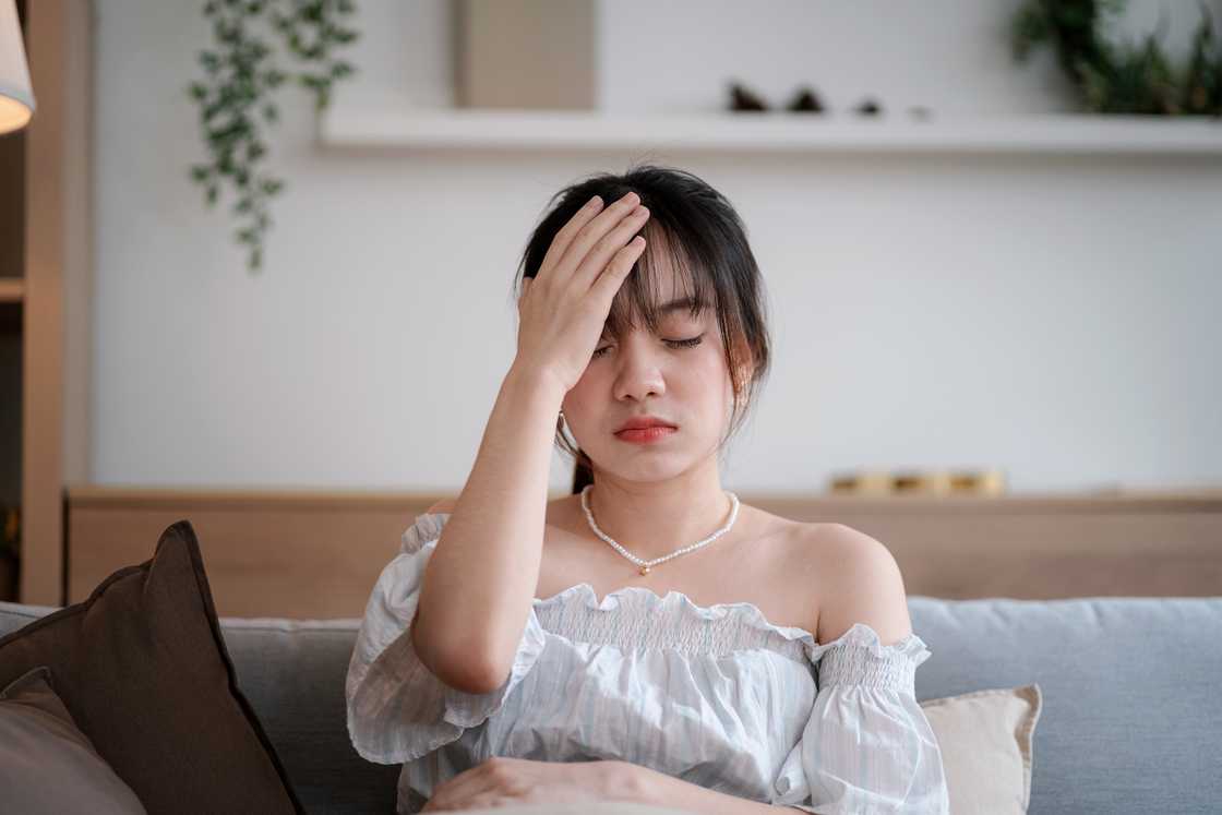 A distressed woman sitting with her head in her hand A distressed woman sitting with her head in her hand