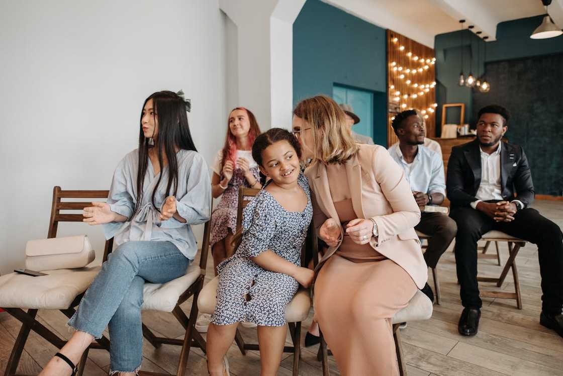 People sit on chairs during a small church gathering.