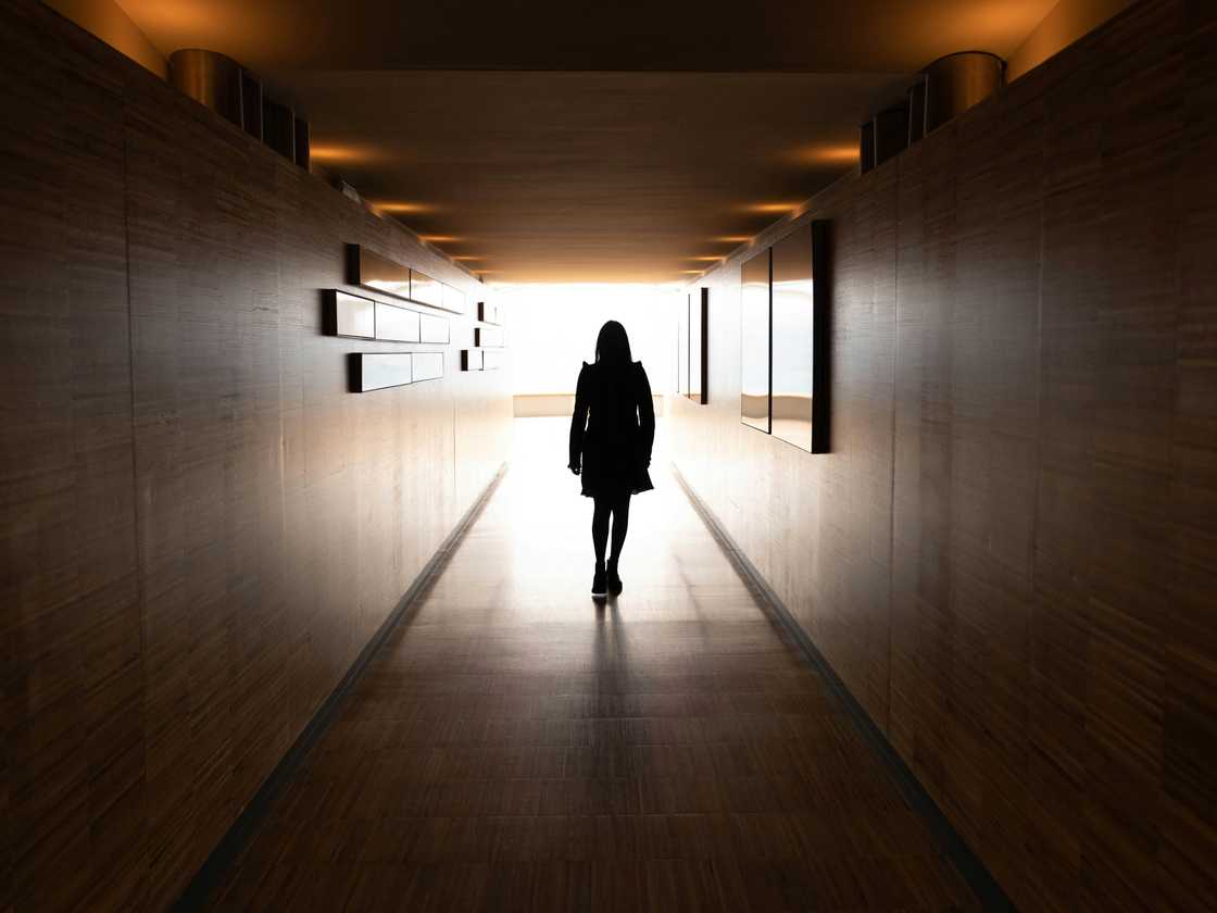 A woman walking down the hallway A woman walking down the hallway
