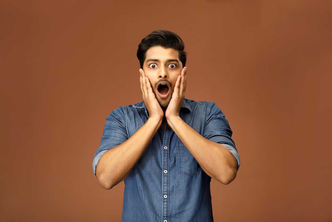 A man holds his head in shock A man holds his head in shock