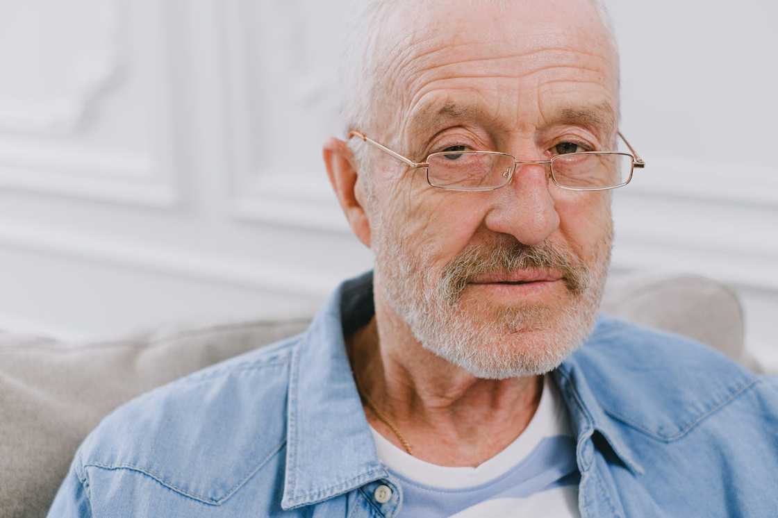 Close-up portrait of an older man wearing glasses indoors. Close-up portrait of an older man wearing glasses indoors.