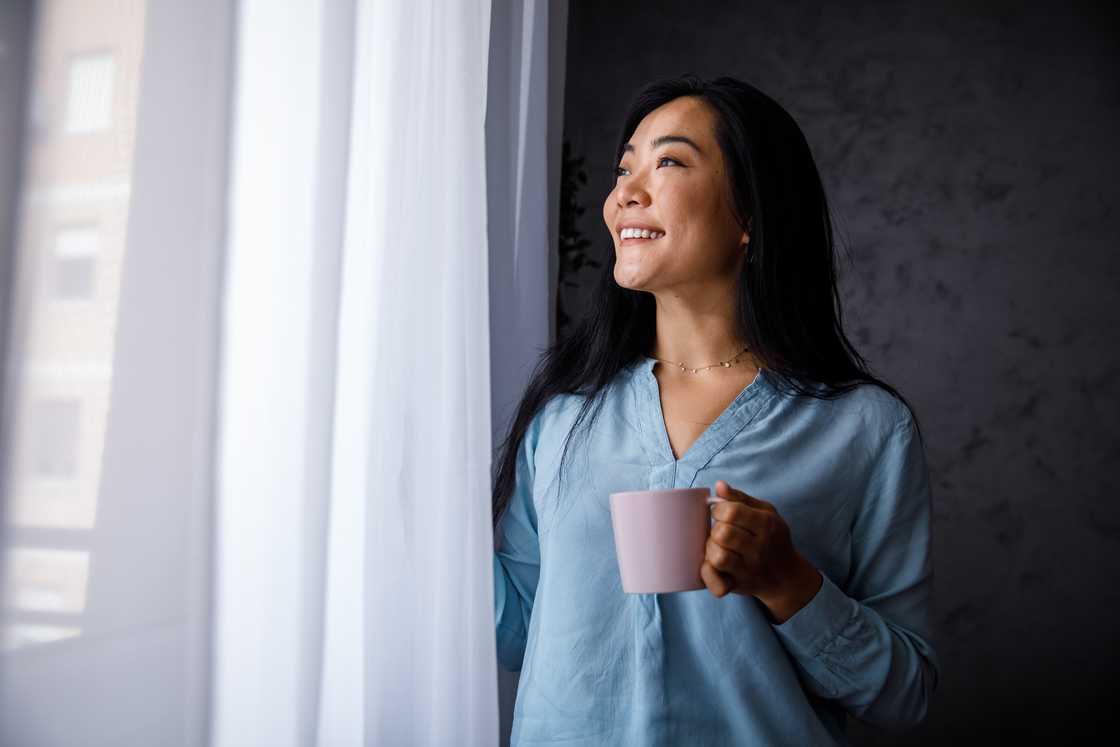 A lady by the window sipping tea