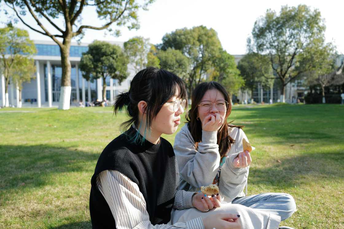 Two friends having a light conversation outdoors Two friends having a light conversation outdoors