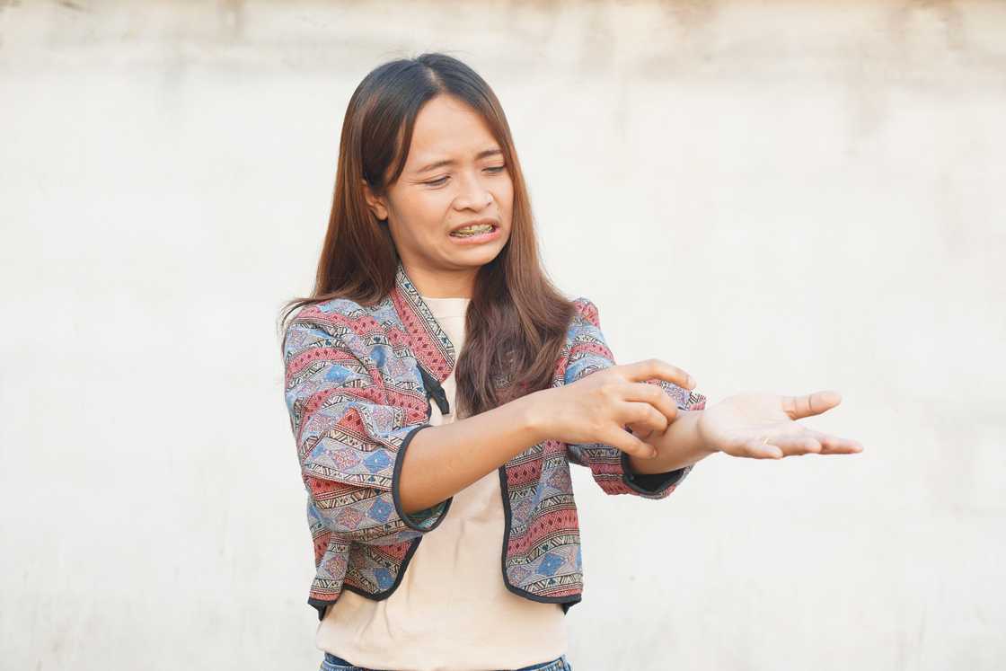 Asian woman staring at her blistered hands