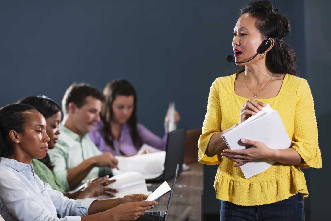 A coach stands before a group of call centre trainees during accent training. A coach stands before a group of call centre trainees during accent training.