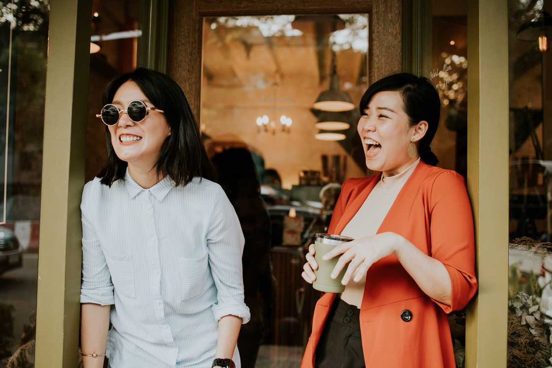 Two women laughing while gossiping