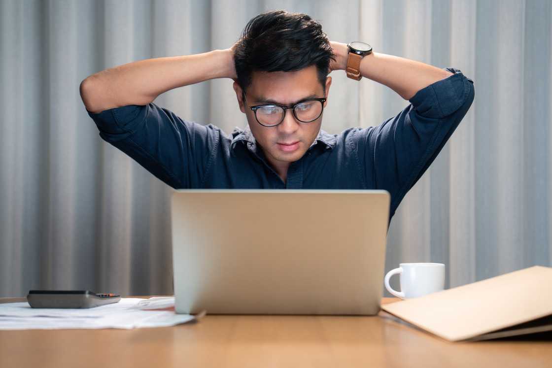 A stressed out man uses his laptop A stressed out man uses his laptop