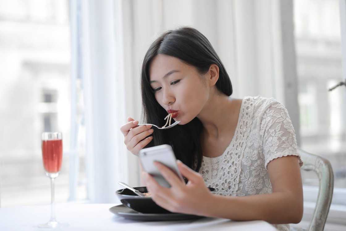 A woman reacts happily to a message on her phone. A woman reacts happily to a message on her phone.