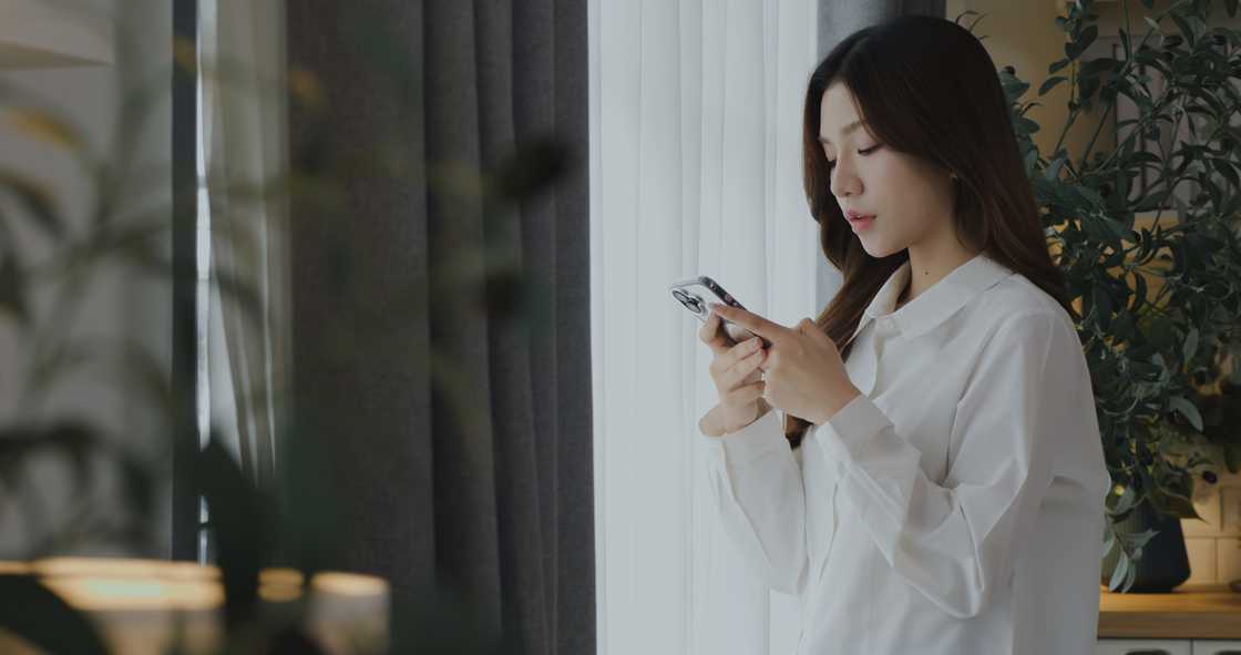 A woman scrolls on her phone